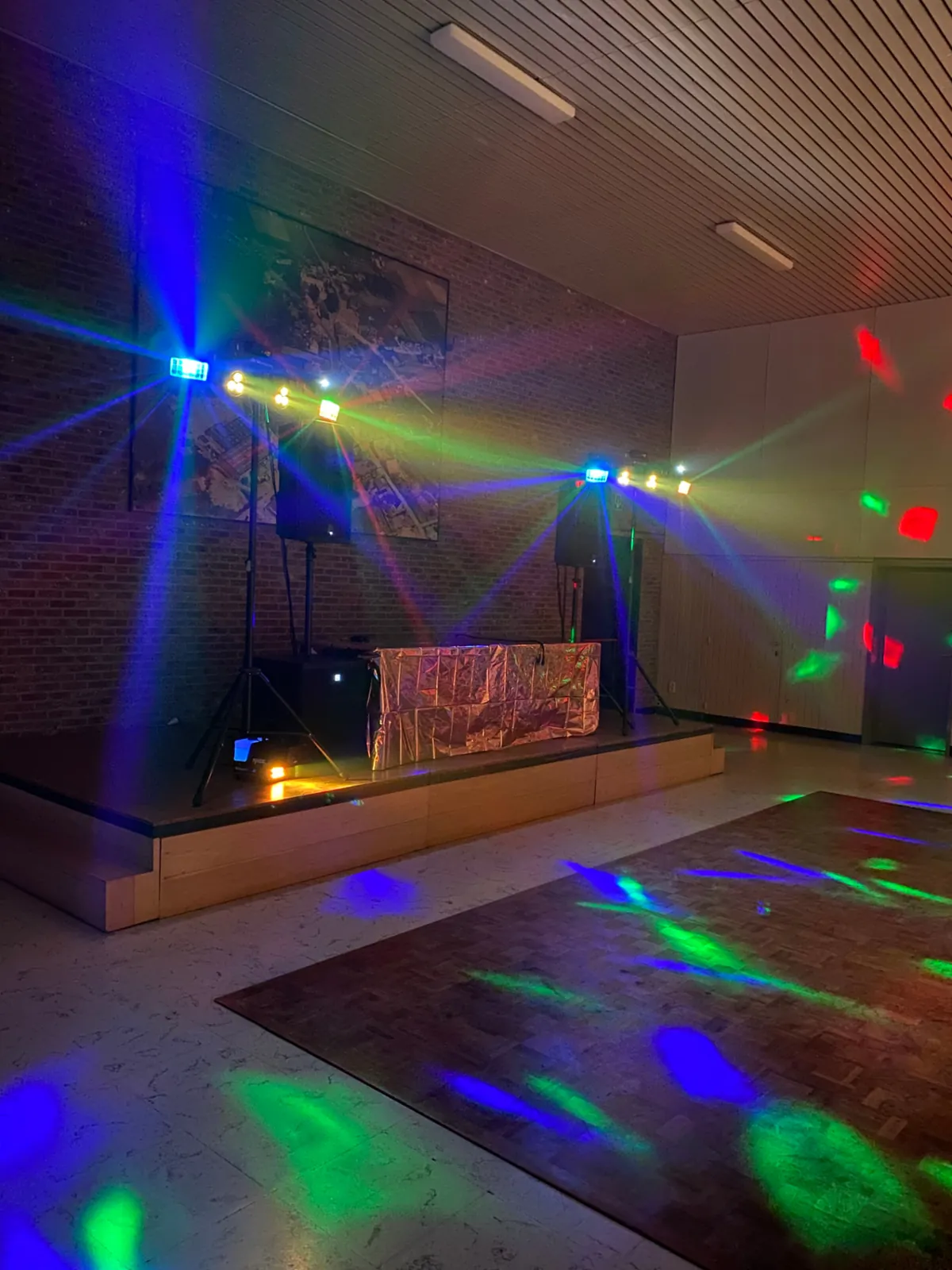 Podium met gehuurde lichtshow en geluidsinstallatie in een feestzaal