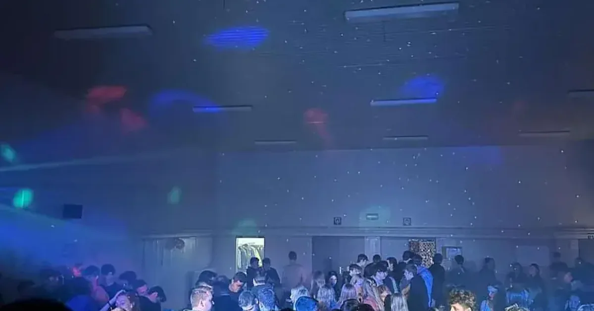Feestende gasten op een dansvloer met kleurrijke discolichten