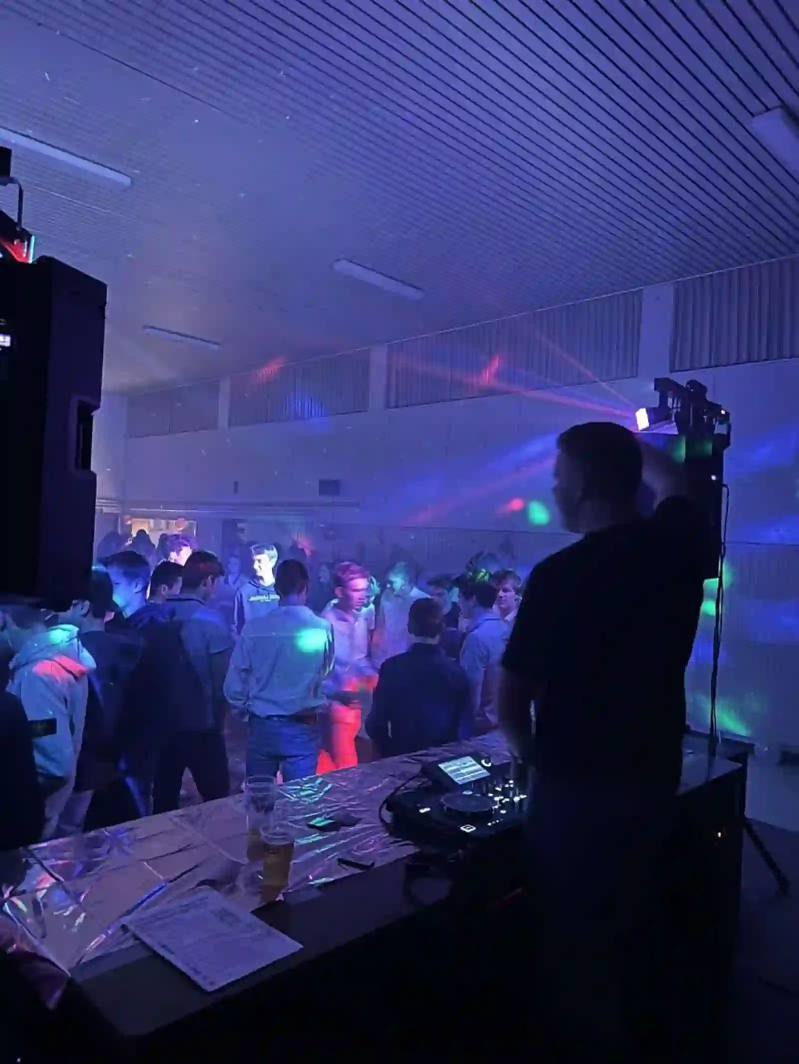 DJ-booth met dansende zaal en kleurenlicht in Wuustwezel