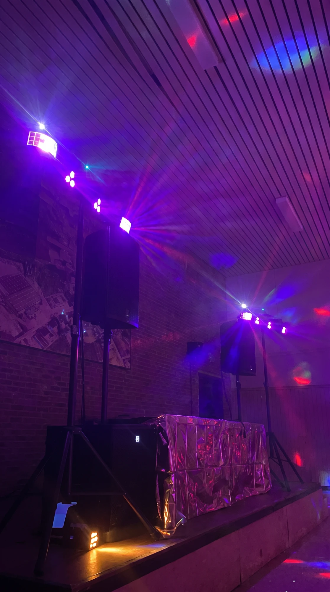 DJ-booth met speakers en gekleurde verlichting op een podium