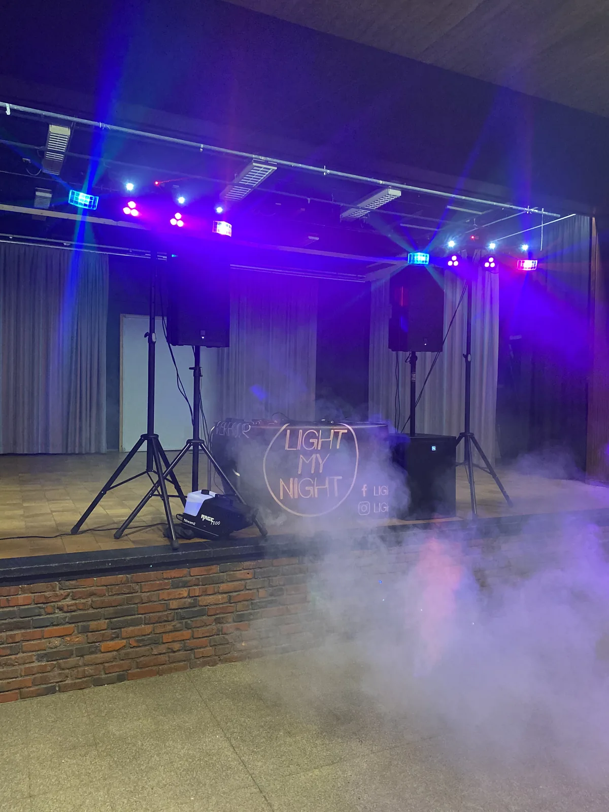 Podium met lichtbruggen, speakers en rookmachine speelklaar opgebouwd
