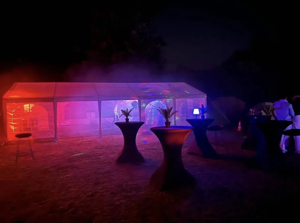 Partytent met roze en paarse feestverlichting en rook tijdens een vatje