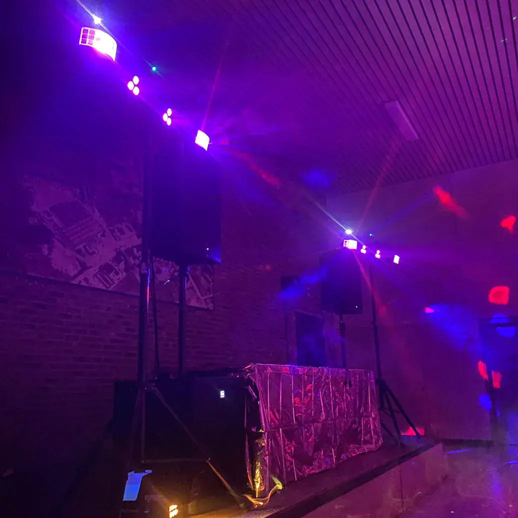 Feestopstelling met DJ-controller, geluidsinstallatie en sfeerverlichting