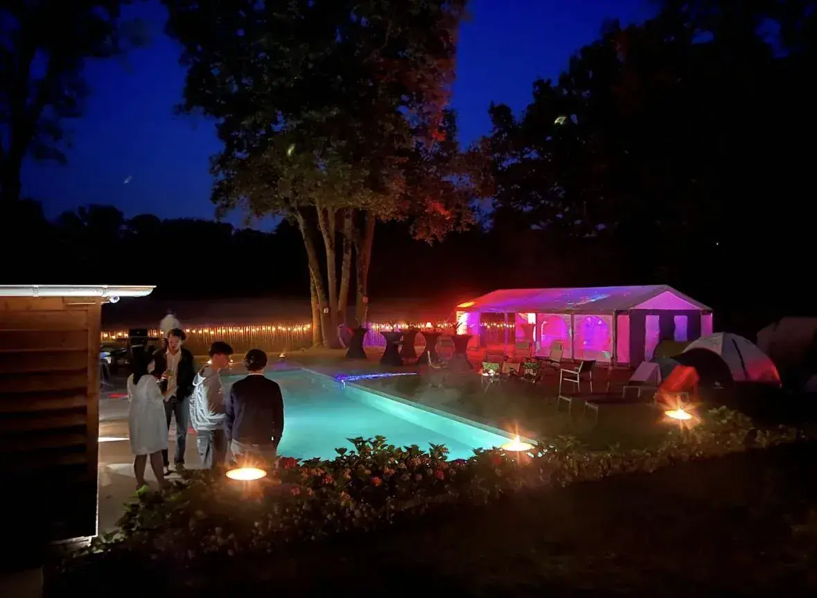 Tuinfeest met verlicht zwembad, paarse partytent en gehuurd geluid